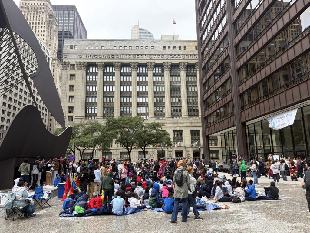 People standing and sitting during the one minute of silence for peace.